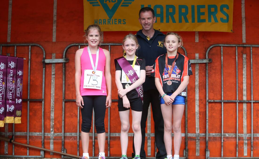 Grade 3-4 girls mini-mile placegetters Emily Everist (2nd), Bethany Dean (1st), Brianna Dunn (3rd)  and Bendigo Harriers president Geoff Jordan. 