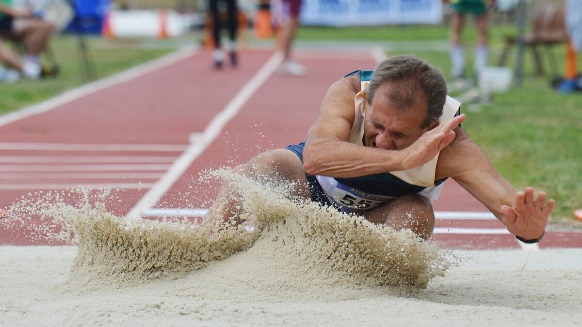 SAND FLIES: Eaglehawk's Terry Hicks lands in the pit as he contests the long jump representing Australia in the 55-59 years decathlon. Picture: BRENDAN McCARTHY
