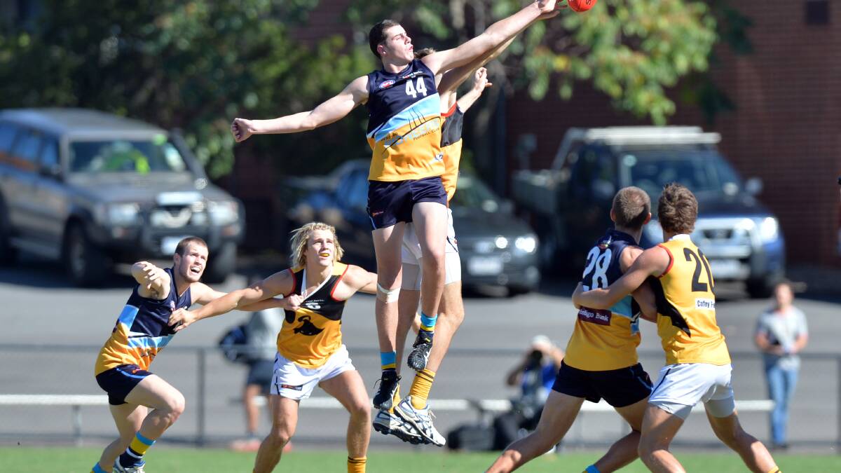 Eaglehawk's Jack Lawton leaps to win this centre-bounce duel in the Pioneers clash with Dandenong. 
