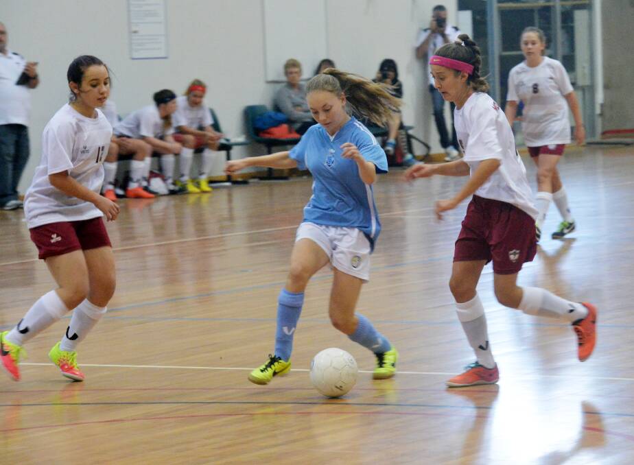 RIVALS CLASH: New South Wales City takes on Queensland City White in the 14-girls match on day two of the Australian Futsal schools championships in Bendigo. Picture: BRENDAN McCARTHY