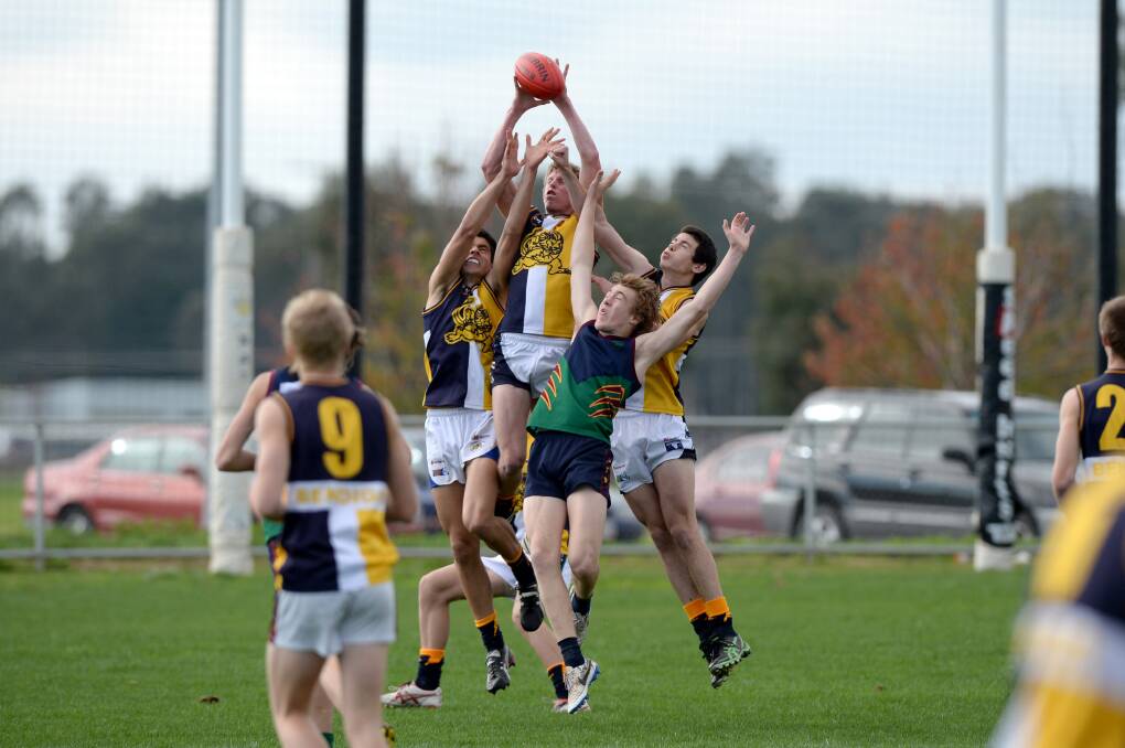 FLYING HIGH: Bendigo Senior Secondary College Lions outnumber Catholic College Bendigo in this marking duel in Tuesday's clash at Epsom-Huntly Reserve. Picture: JIM ALDERSEY