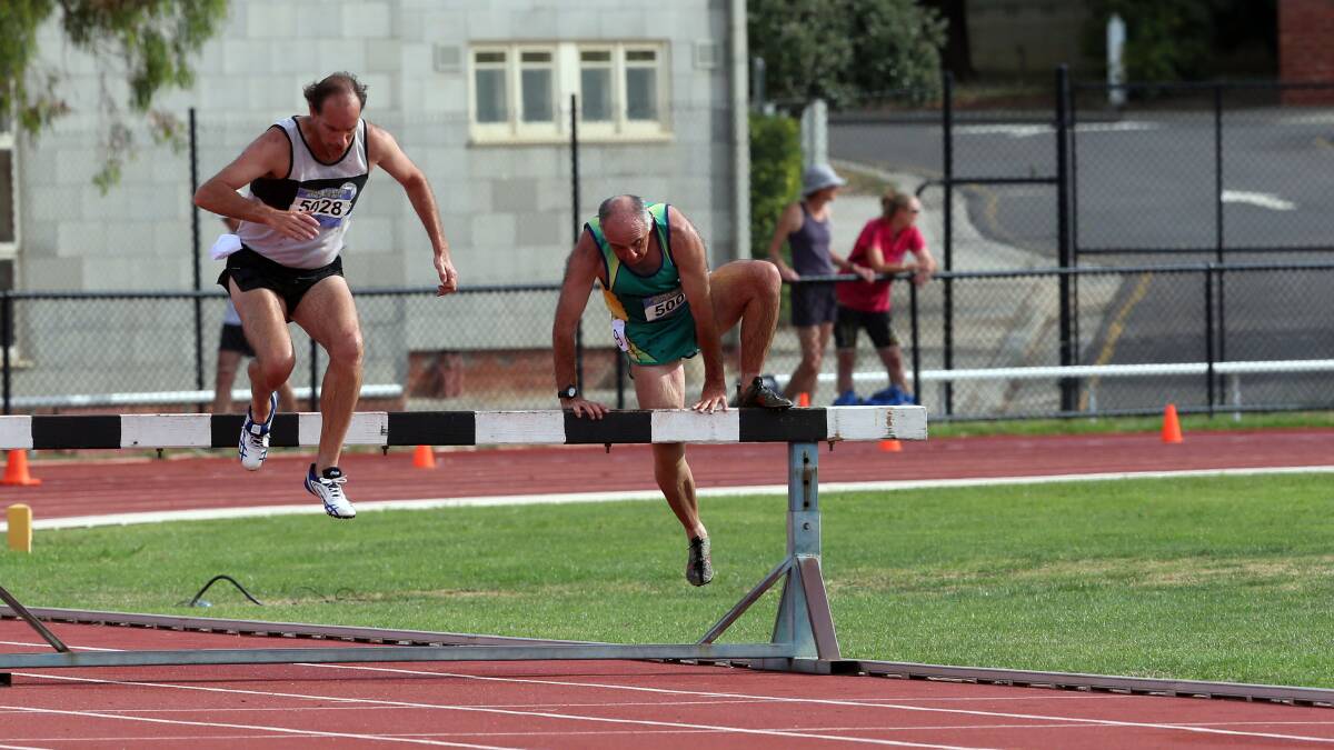 Brendan Magill and Tony Dell clear the obstacle in the 50-54 years 2000m steeplechase. Picture: LIZ FLEMING 