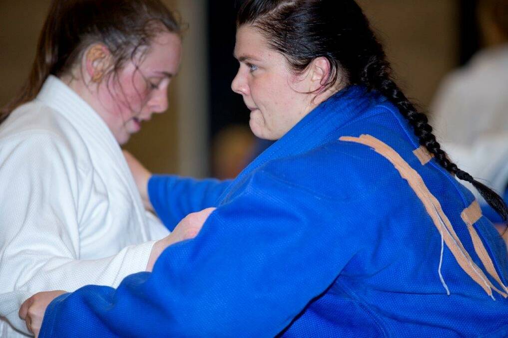 Tegan, right, grapples with an opponent on the judo mat at the AIS.