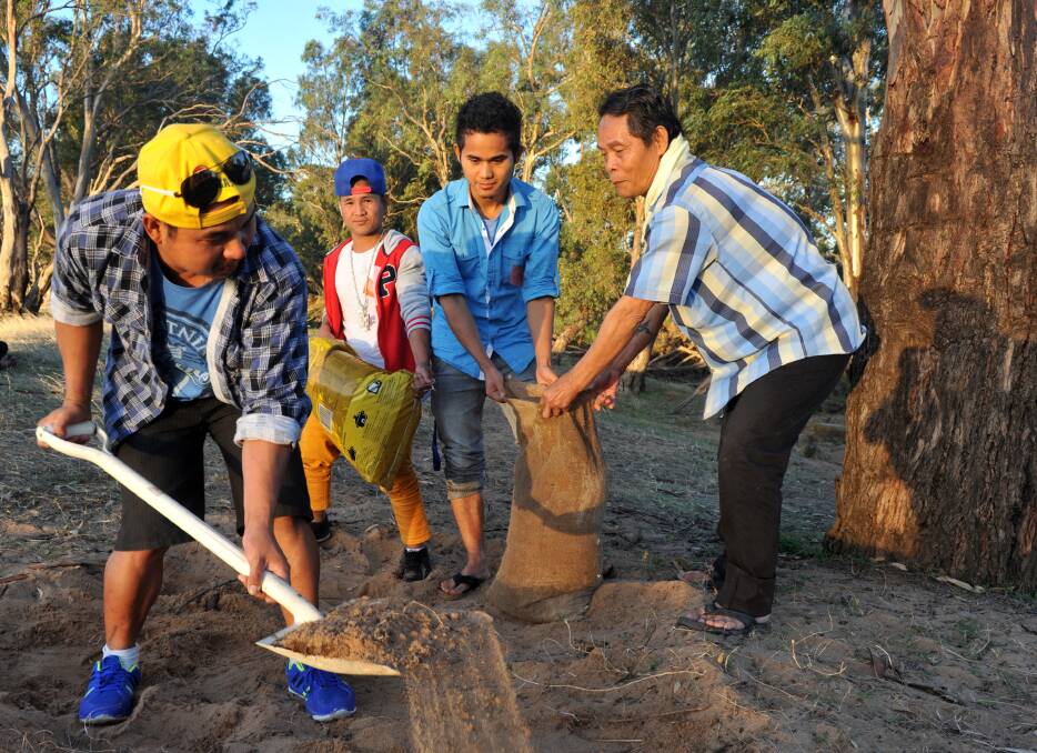 Aung Tin, Tun Tun, Kyaw Kyaw, Tho Tho
fill sandbags to make a temporary pond for the fish
Picture: BRENDAN McCARTHY
