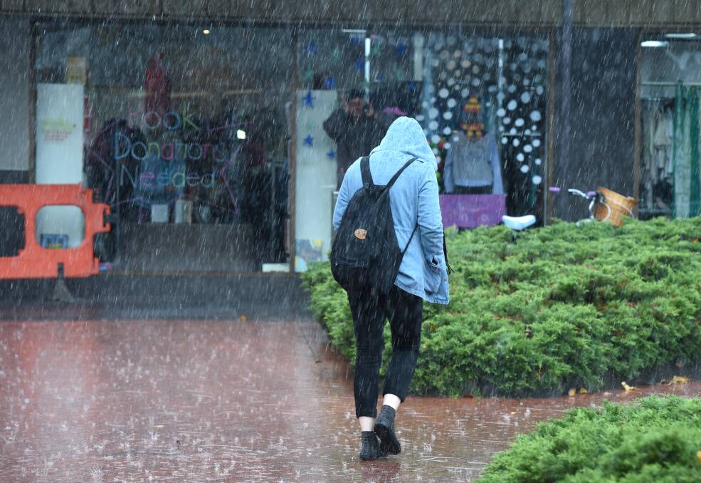 RAIN: A person gets caught in the wet in Bendigo. Picture: JODIE DONNELLAN
