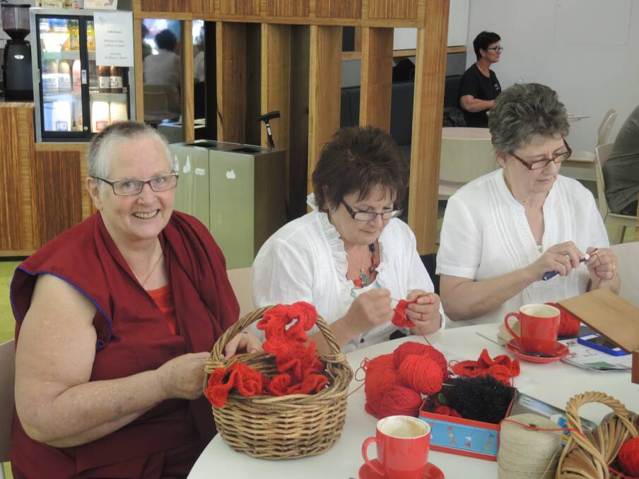 Tenzin Lozang, Chris Schembri and Jennifer Moore make poppies at the community craft group at the Bendigo Library. Picture: MADDIE WINES