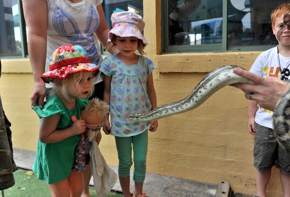 Milla, 2, and Jemma Saunders, 5, meet Sam the carpet python. Picture: JODIE DONNELLAN 
