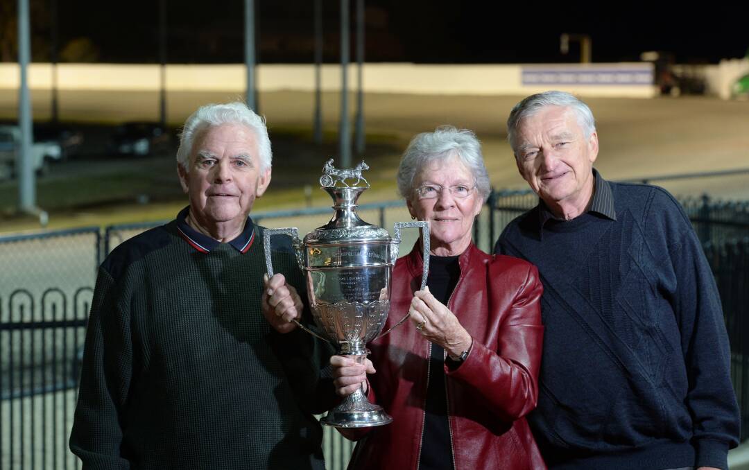 NEW HOME: Neil and Sue Mayne and Norm West with the 1917 New Zealand Trotting Cup at Lord's Raceway. Picture: JIM ALDERSEY
