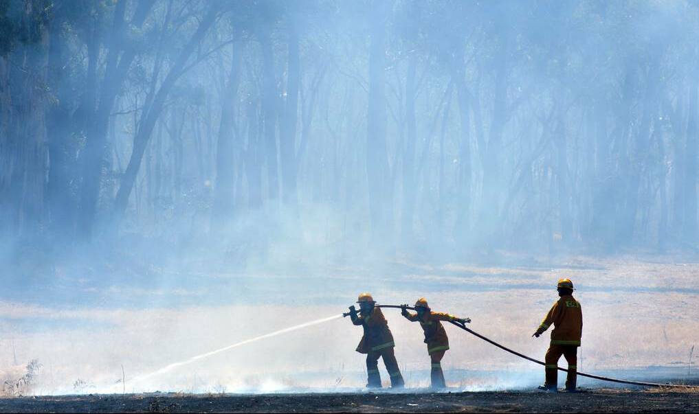 TEAM WORK: Fire crews work to control a blaze in Maiden Gully in February.