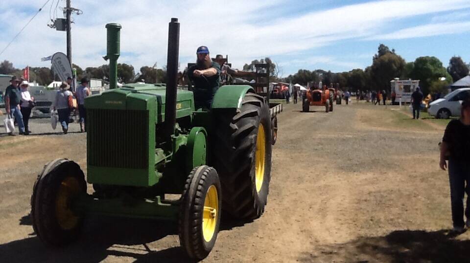 The vintage tractors make their way past the Agribusiness Pavilion.