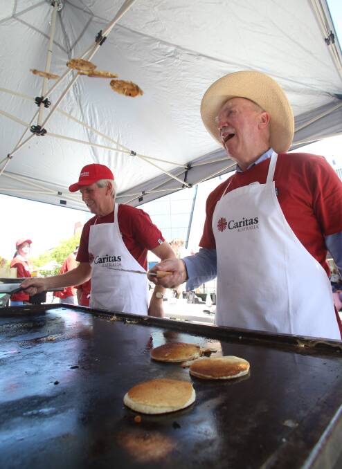 Tossing the pancakes for Caritas is Bernie White. Picture: PETER WEAVING