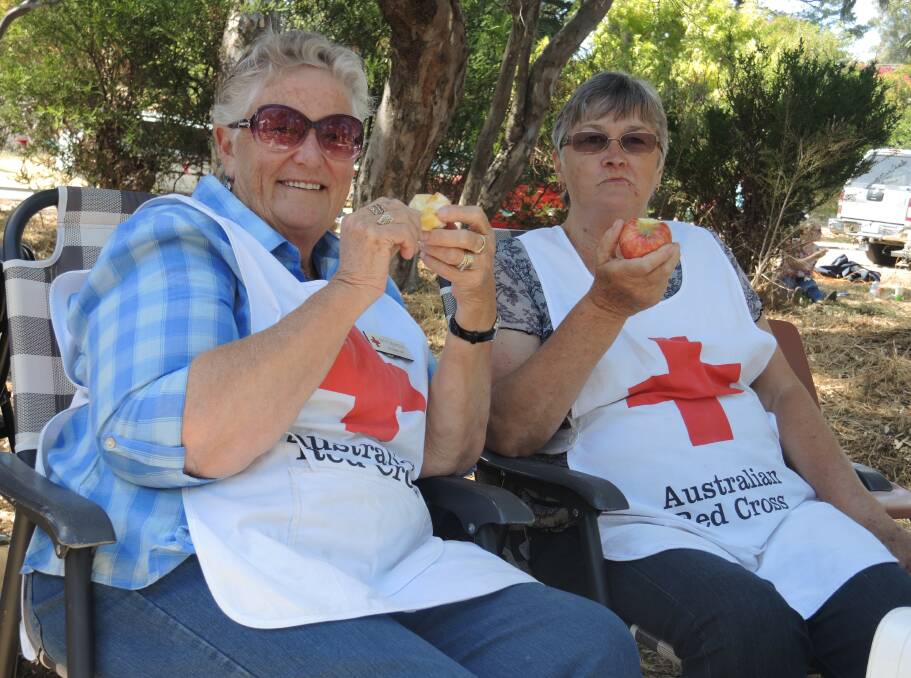 Betty Adamson and Elaine White from Castlemaine Red Cross enjoy an apple snack during fundraising duties. Picture:  DOROTHY COOK
