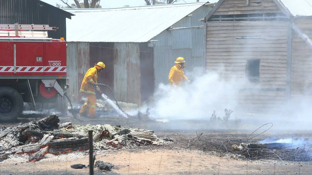 MOPPING-UP: A shed destroyed at Laanecoorie in a grass fire. Picture :  PETER WEAVING