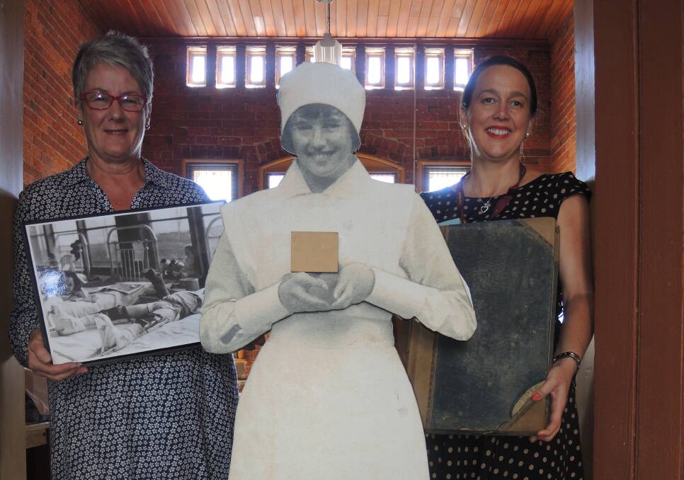 DISCOVERY: Jan Monro, left and Angela Gallagher with a display prop dressed in old-fashioned nursing uniform. Picture: LEIGH SHARP