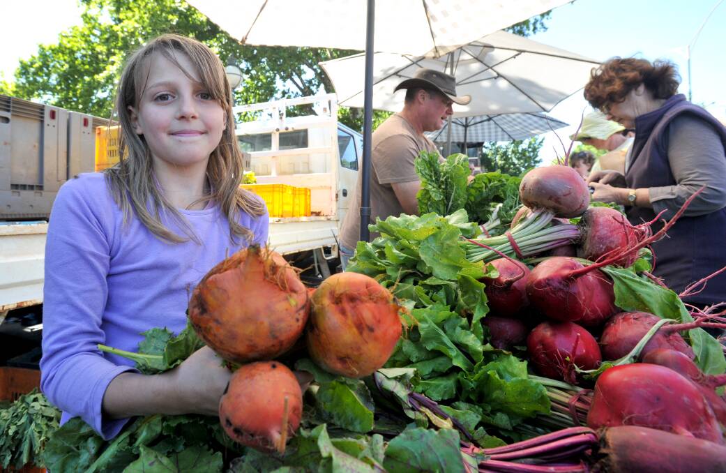Amber Tatman helping the family business Spring Creek Organics sell produce at Bendigo farmers market.  Picture: MATT KIMPTON