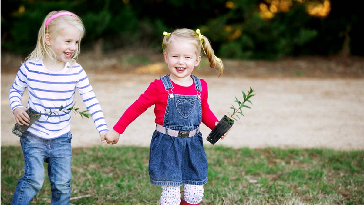 SMILE: Alice Van Dam and Isla Woodhouse, both 3, off to plant for their mums. Picture: KIM SELBY PHOTOGRAPHY