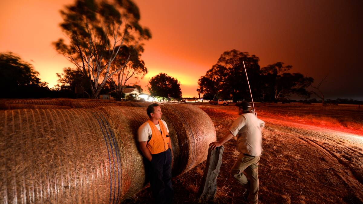 FIERY SKY: Darren Jasper and MIck Dalziel monitor the fire on a property next to the fire in the Grampians National Park. Picture: THE AGE
