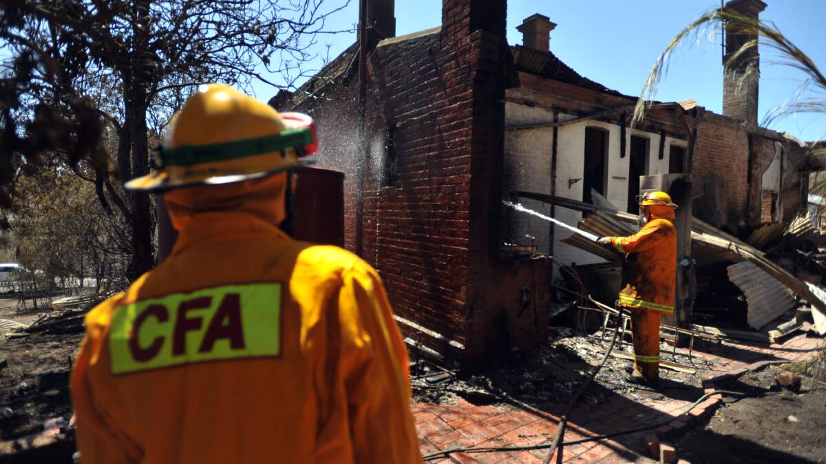 FEBRUARY 9, 2009: CFA members form Sedgwick checking on a smouldering house in Eaglehawk. Firefighters were warning people to avoid fire ravaged areas due to unstable buildings collapsing and possible exposed mine holes. Picture: Nick McGrath