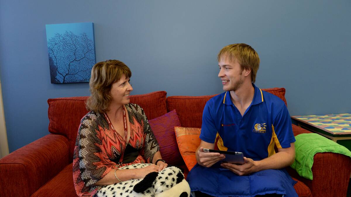 SENSE: Manager of Child and Adolescent Mental Health Service Lorraine Flynn with Bendigo Brave player Kevin Probert and some of the sensory items including a weighted dog, pillow and also an iPad. Picture: JIM ALDERSEY
