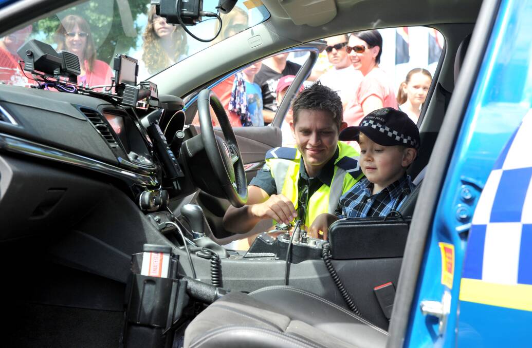 RIDE: Six-year-old Ryan Healy takes a ride with Constable Sheldon Robertson. Picture: JODIE DONNELLAN 