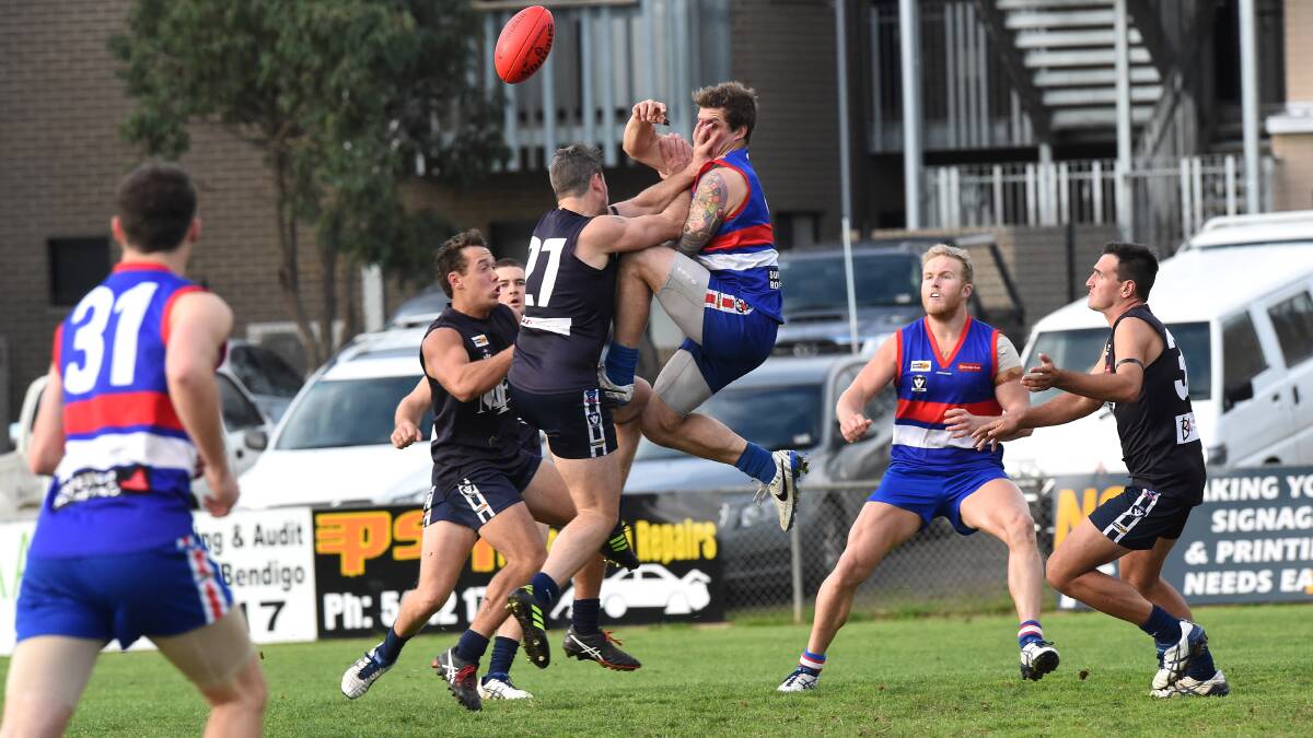 OUCH: North Bendigo's Jeremy Mills cops a hand in the face from Mount Pleasant's Chris Black.