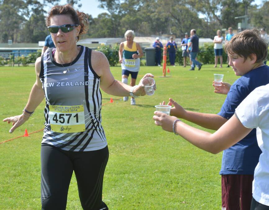 THIRSTY WORK: Sharon Wray grabs a drink during her run. Pictures: BRENDAN McCARTHY.