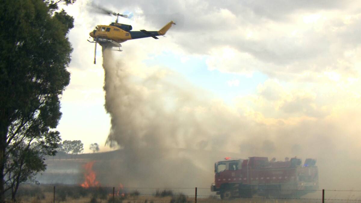HELP FROM ABOVE: A chopper helps a CFA ground crew battle the fire. Picture: APEX IMAGERY