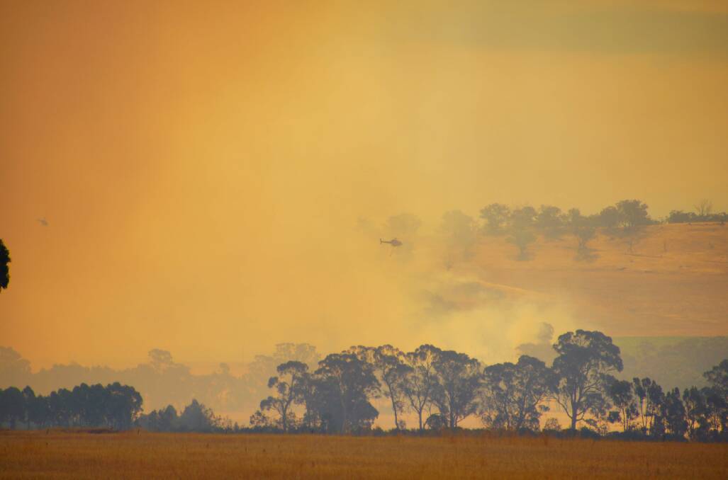 SMOKE HAZE: A chopper works the Toolleen fire. Picture: LUKE WALLIS