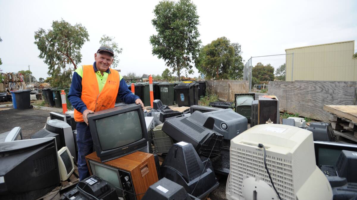 COLLECTING: Assistant manager of the Eaglehawk Recycle Centre Shane Hogan with the pile of old televisions. Picture: JODIE DONNELLAN 

