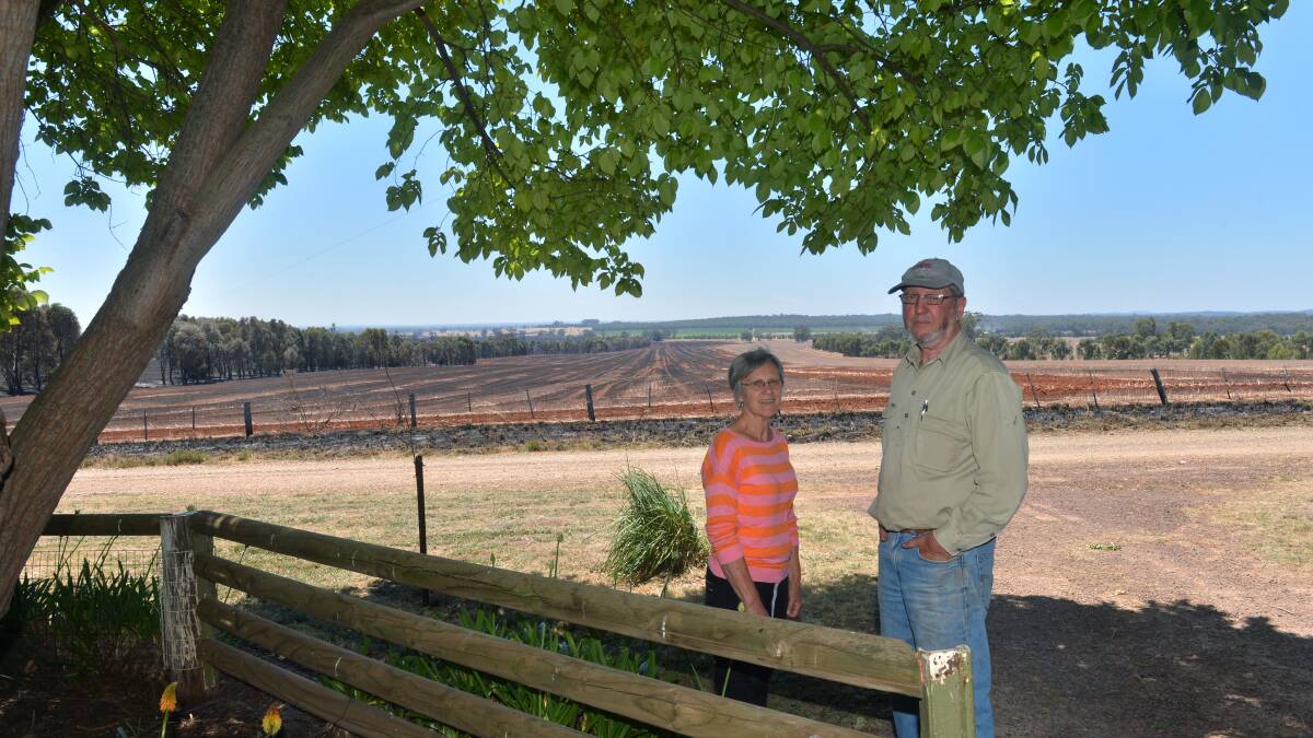 RELIEVED: Peter and Norma Hamilton survey the fire damage. Picture: PETER WEAVING