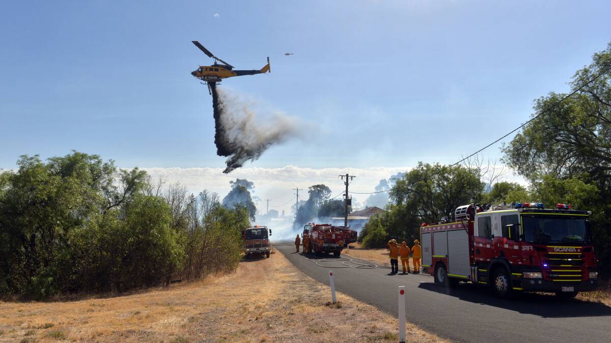 DANGER: A water-bombing helicopter drops water over the Long Gully fire.
