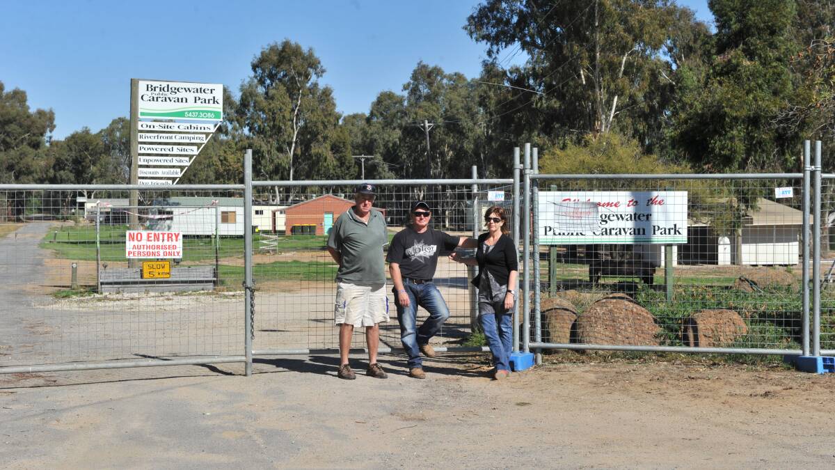 POST-FLOOD: Bridgewater Caravan Park in April 2011.
Mick O'connor, Paul and Lindy Crawford pictured at the gate. Photo: PETER WEAVING
