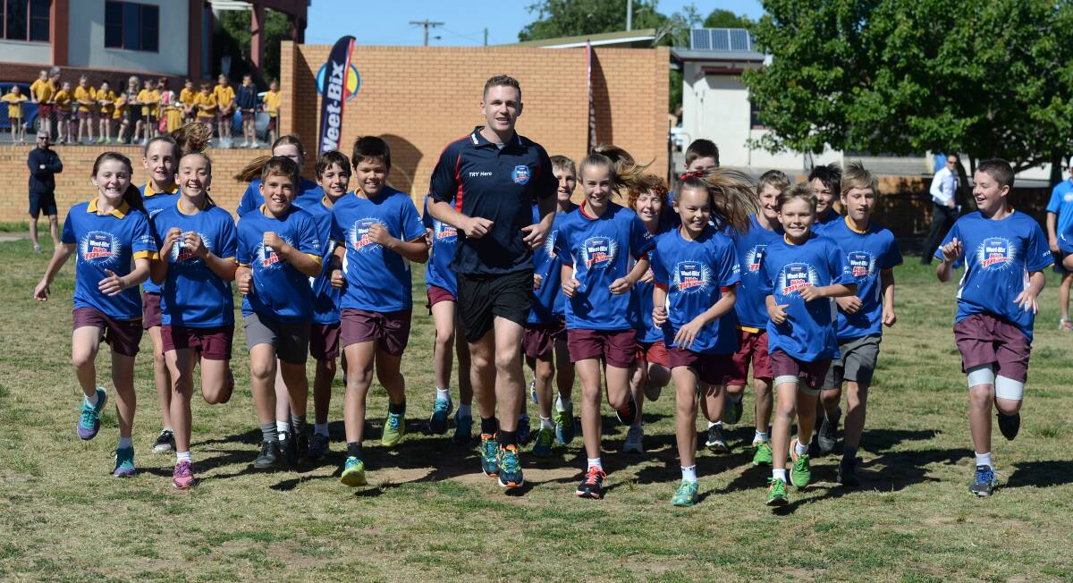 EXCITED: Joel Selwood goes for a run with students from St Therese's Primary School. Picture: JIM ALDERSEY