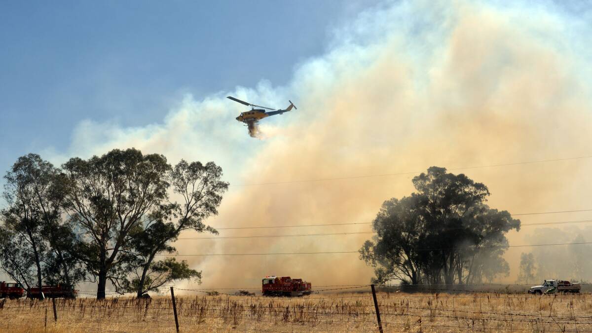 A water-bombing helicopter drops water over the Maiden Gully fire. Picture: Brendan McCarthy. 