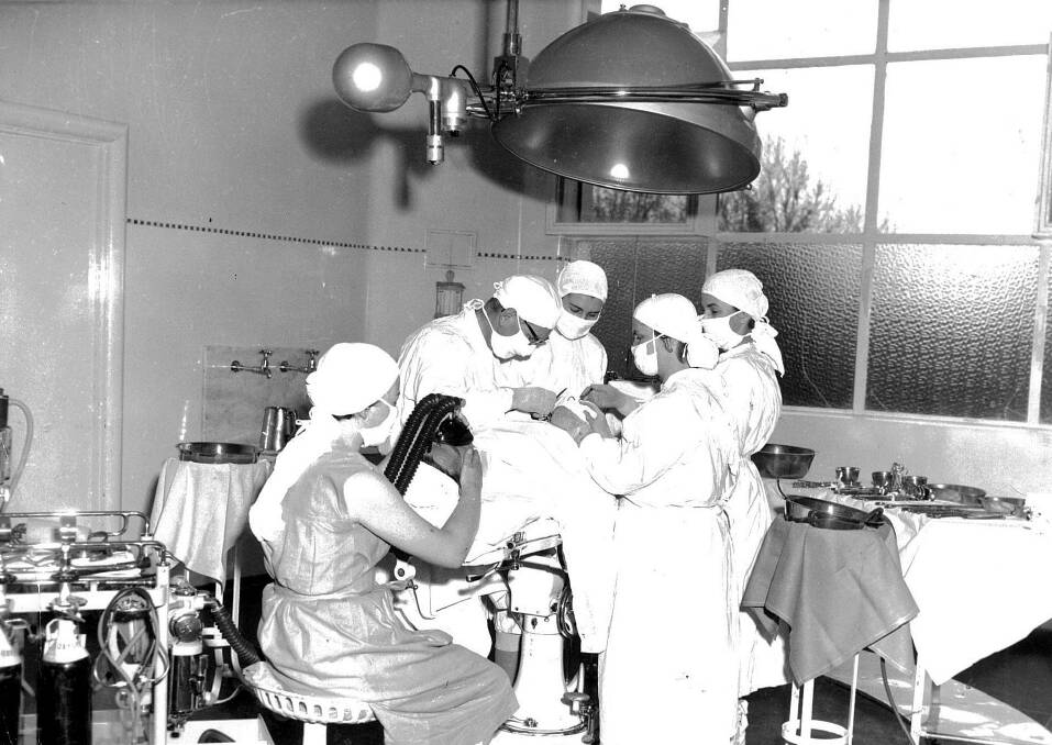 1958 Bendigo Base Theatre. A mock set-up was organised for the Bendigo Advertiser to take a photo of the new theatre light. Pictured are Aileen Howitt (anaesthetist), Jock Duguid (an orderly, playing the patient), Dr Slater (medical super playing surgeon), assistant Elizabeth Fowler, first assistant Lou Pocock (sister in charge of Kurmala Theatre) and the instrument nurse was Sister Gwen McDonald (sister in charge of the Base Theatre). 