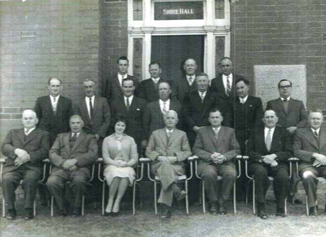 1960 Shire of Newstead - Centenary Council Meeting - Wednesday October 12, 1960. Rear, L to R: P.G Shaughnessy (Engineer), Crs. W. N Mein, H. W Robinson, L. A. Mein. Centre, L to R: Crs. H. H. Hamblin, J. A. Never, J. Heagney, N. Ford, G. Shill, A.G Ryland, W. Backway. Front, L to R: Crs W. Cassidy, L. Stevens, Miss M. Harris (Asst. Secretary), Cr. J. Powell (President), Mr. D. J. R Dunton (Secretary), Crs. J. H Butler, A. Hopkins. 