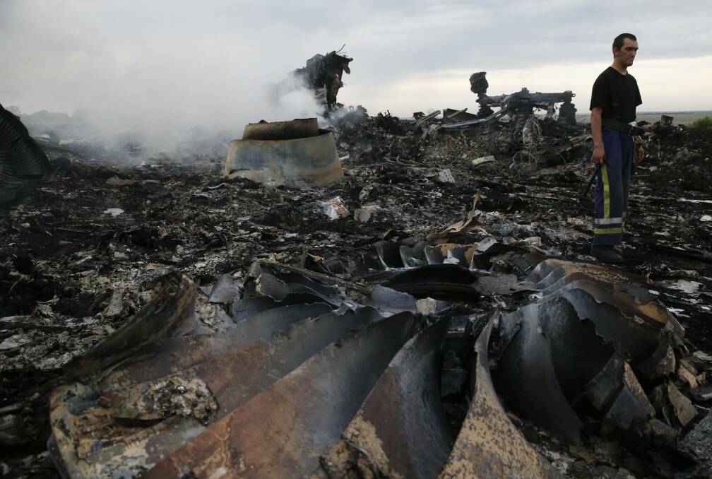 An Emergencies Ministry member walks at the crash site of the Malaysian airliner Flight MH-17 which was brought down over eastern Ukraine on Thursday, killing all 295 people aboard and sharply raising the stakes in a conflict between Kiev and pro-Moscow rebels in which Russia and the West back opposing sides. Picture: REUTERS