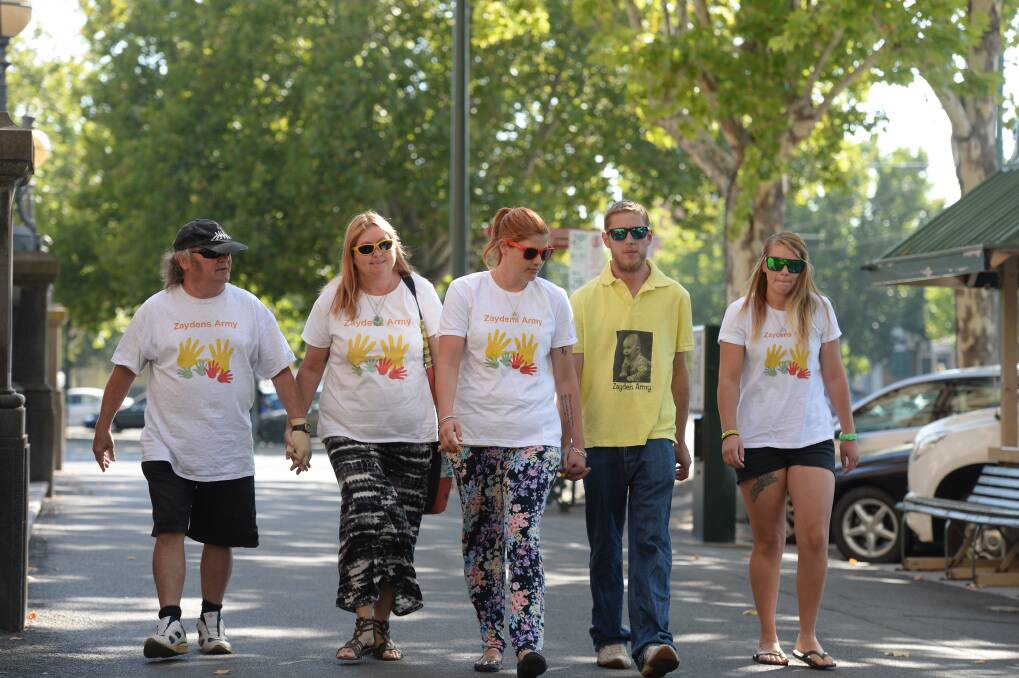 Zayden's family has arrived at court, with mother Casey Veal and extended family wearing Zayden's army T-shirts.