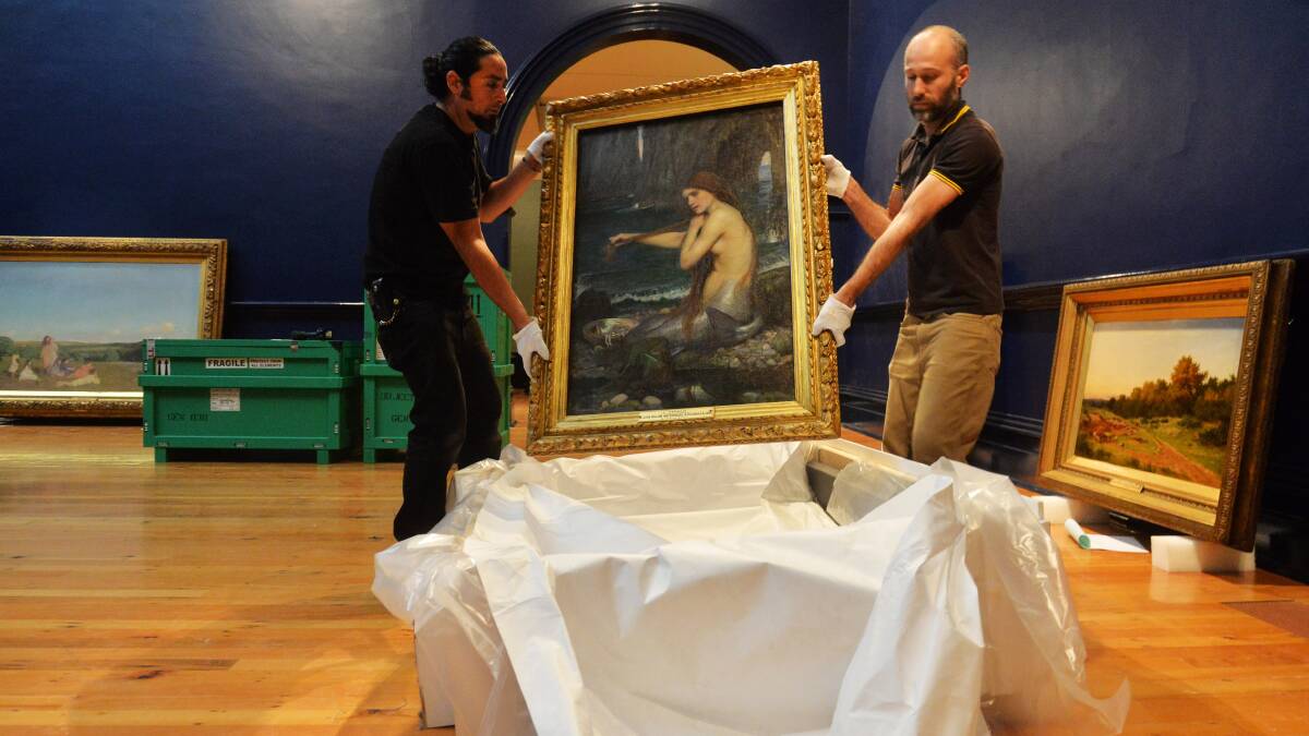A MERMAID: Gallery workers unpack an iconic painting. Picture: BRENDAN MCCARTHY