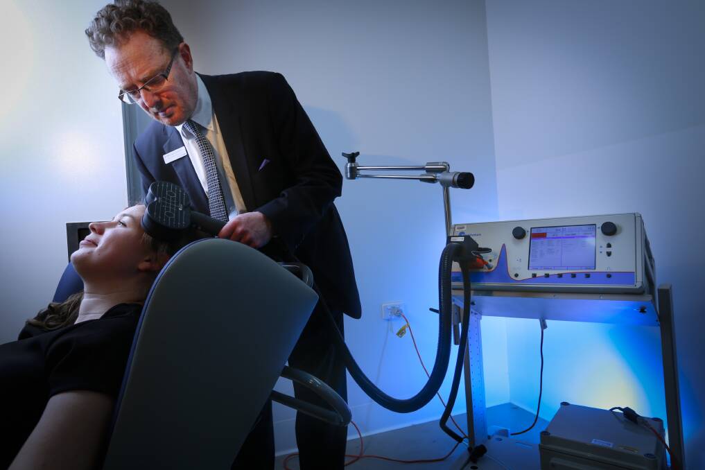 Dr Michael Gordon with a machine delivering magnetic therapy to a teenager's brain to try to treat depression. Picture:Eddie Jim