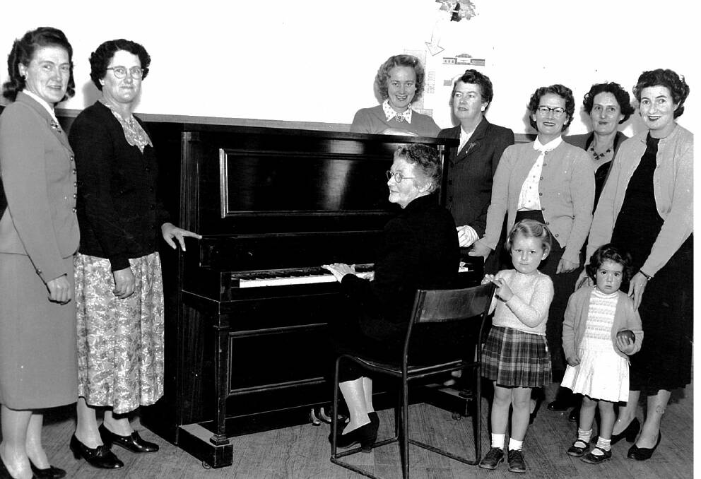 1950s South Bendigo Progress Association Ladies Committee raised the money to buy this piano. From left, Olga Burnett, Mrs Naismith, name unknown, Mrs May (playing the piano), Mrs Robertson and daughter Kay, Mrs Davis and Mrs Polgaise and her daughter. 