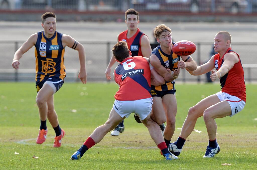 CRUNCHED: Bendigo Gold midfielder Jake Aarts is tackled by two Coburg opponents. Picture: BRENDAN McCARTHY
