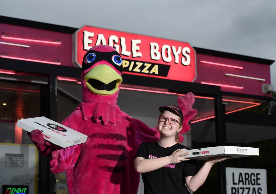 YUM: Eagle Boys Pizza employee Jasmin O'Sullivan with Aussie Eagle. Picture: JODIE DONNELLAN