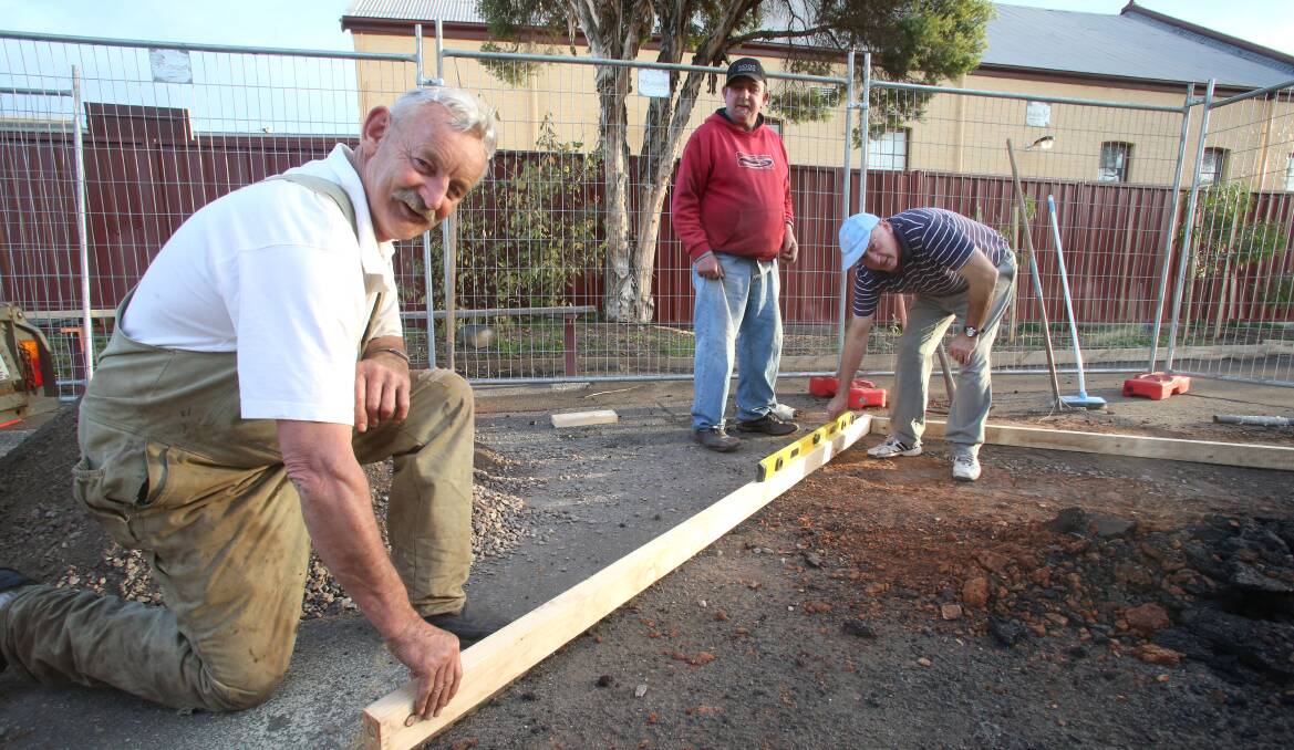 COMMUNITY: Paul Chapman, Des Pittaway and Jeff Bothe lay the foundations. Picture: PETER WEAVING
