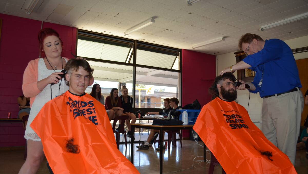 FUNDRAISING: Hairdressers Molly York and Terry Evans of 213 Hair Design shave Travis and Scott Elliott at the Castlemaine Secondary College senior campus. Photo: Courtesy Castlemaine Mail.