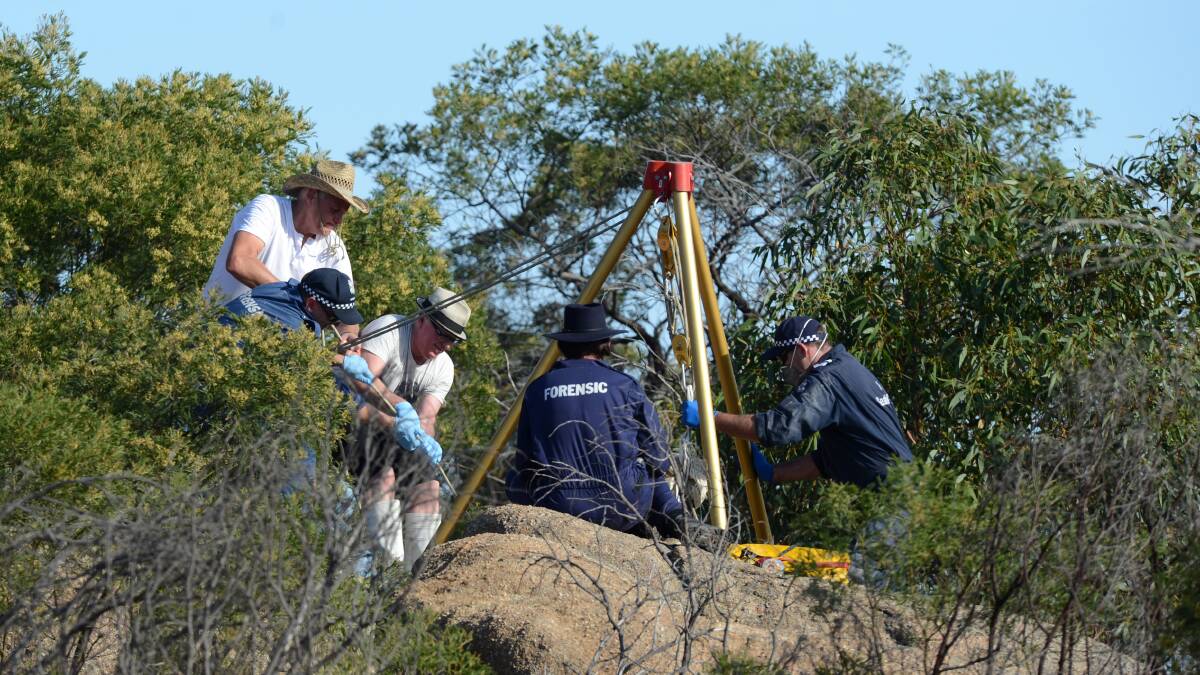 DEATH: Police pull Wayne Amey's body from between two rocks at Mt Korong. Picture: JIM ALDERSEY