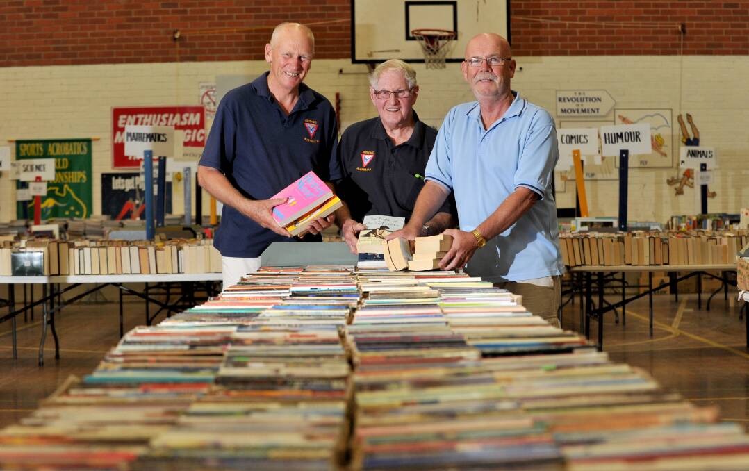 NOVEL IDEA: Colin Lambie, Ian Randall and Larry Wust set up for the Easter book fair. Picture: JODIE DONNELLAN