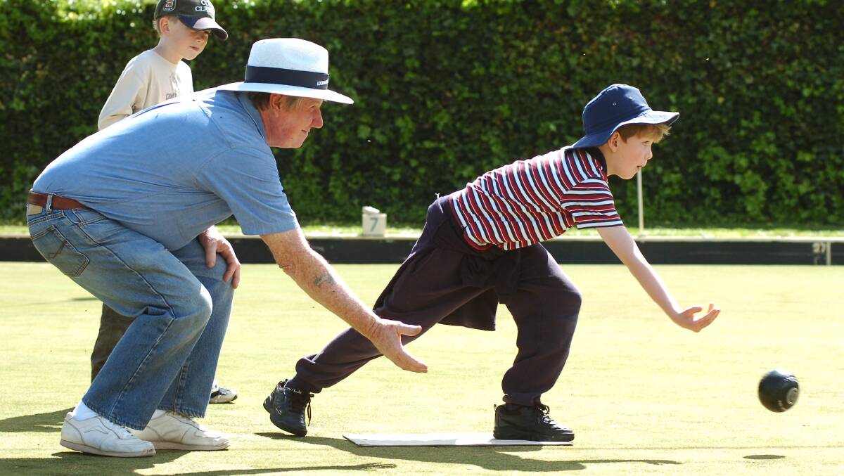 Bill Whitbread of Lockwood Sth Bowls Club guides Lockwood St Primary student Nick Newland 10 through a shot, Billy Caulfield 9 looks on
Pic Brendan McCarthy 261005