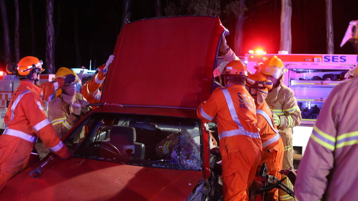 Emergency crews work to free a woman trapped in a car after a collision with a truck in Eaglehawk. Picture: PETER WEAVING