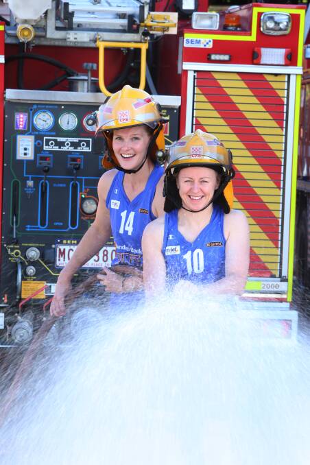 Chelsea Aubury and Kristi Harrower, Spirit players dressed up in gear ready to douse the fire ahead of Sunday's grand final against Townsville Fire.
Photo Peter Weaving 070313